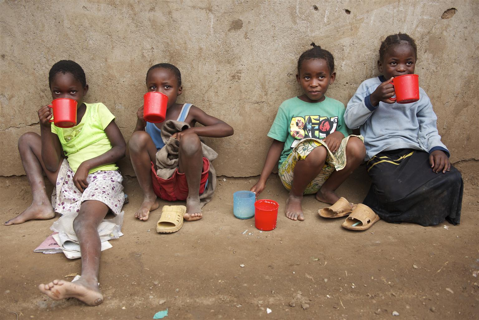Children eat porridge that was just distributed, outside Shamba Primary School, in the Kakuma refugee camp, in the north-western Turkana District. 